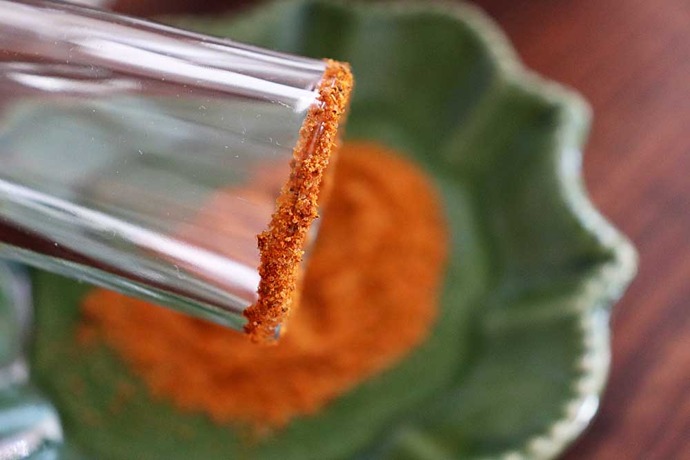 Rim the glass using lime and Tajin seasoning